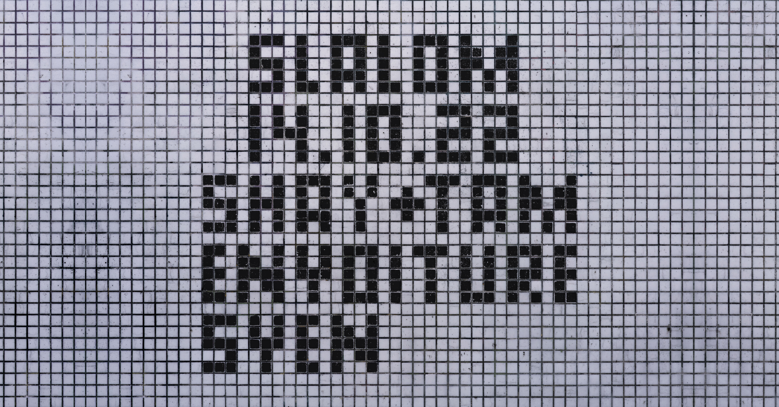 Weisse Kacheln und schwarze Kacheln, die die Wörter: SLALOM 14.10.22 SHAY + TAM ENYOITURE SVEN bilden.