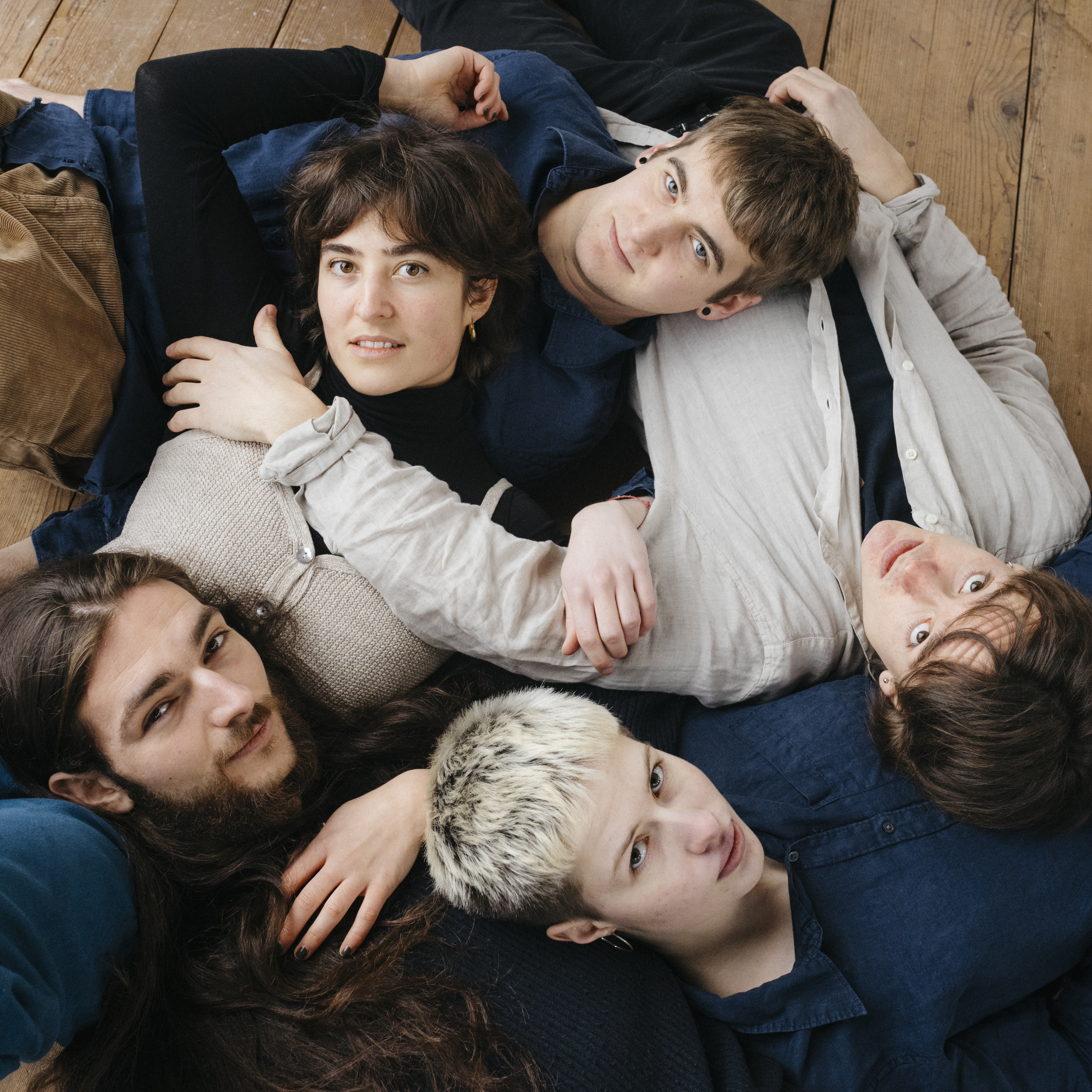Die Band von Anna Rey mit Bandmitgliedern auf dem Boden.