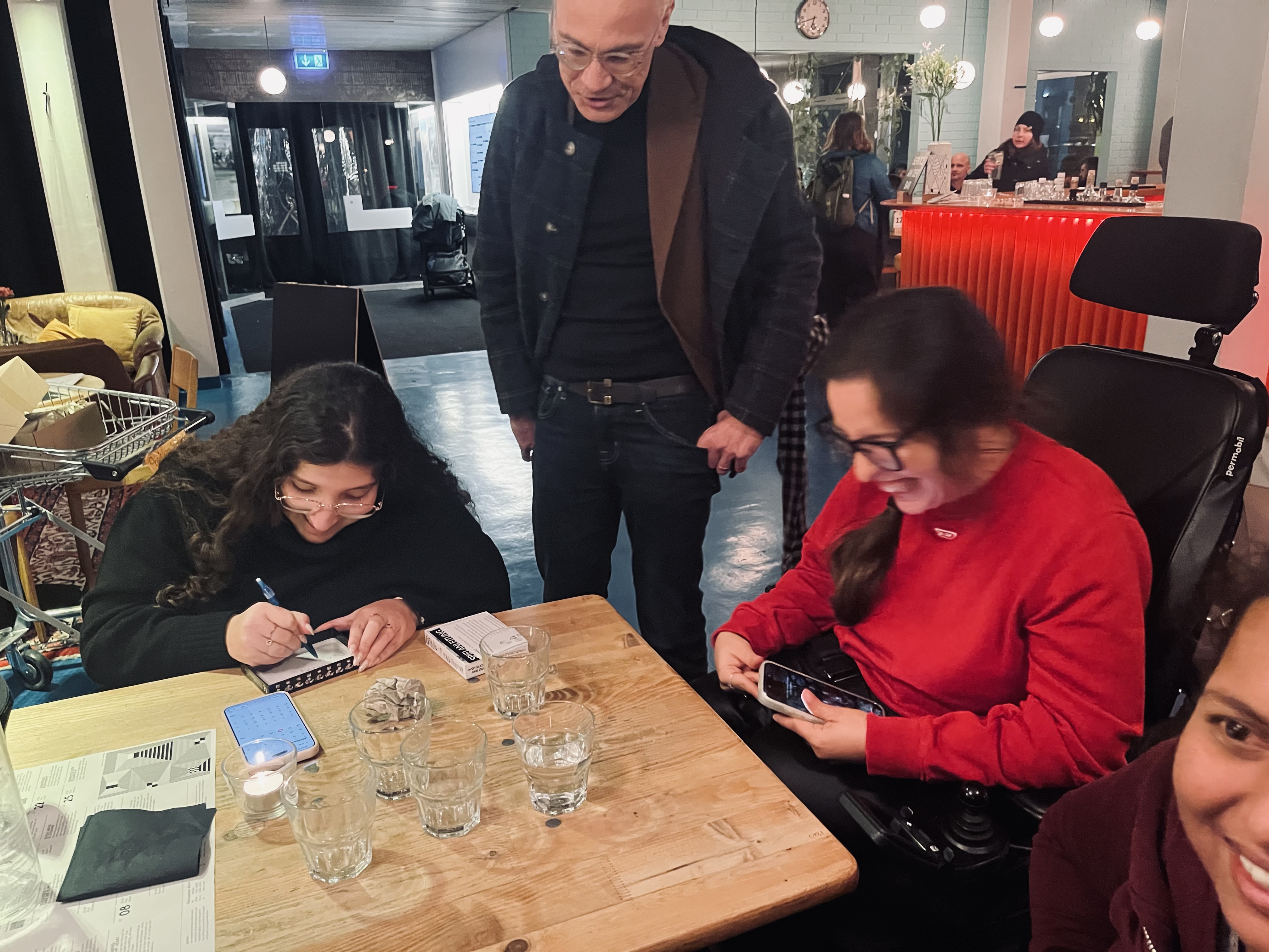 Auf dem Bild sieht man Donita & Elmedina wie sie für Helmut ihre Unterschrift in den Spieldeckel schreiben.