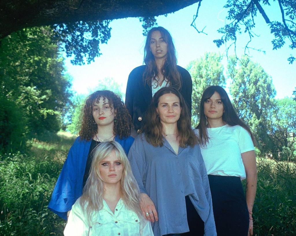 Die Band Emzyg, bestehend aus 5 Frauen, stehen unter einem Baum.