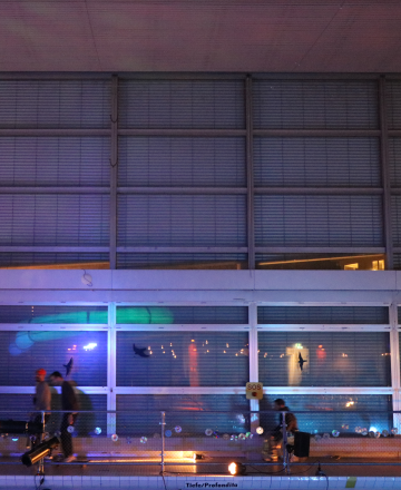 Ich sehe den oberen Poolbereich, wo Gäst*innen um den Pool herumfahren auf dem Rollstuhl. Der Rollstuhl wird von Fussgänger*innen angeschoben