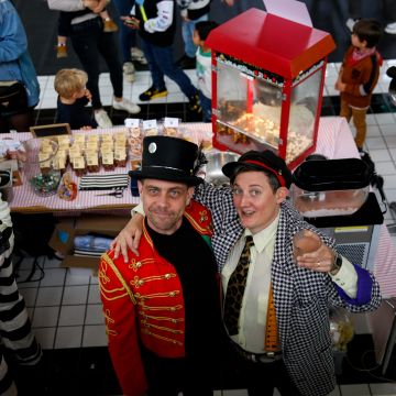 zwei menschen schauen in die kamera und halten ihr glas zum prosten hoch