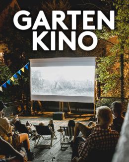 Ein Fotografie von der Gartenkinoleinwand in der Nacht, das Publikum sitzt vor der Leinwand und schauen einen Film an.