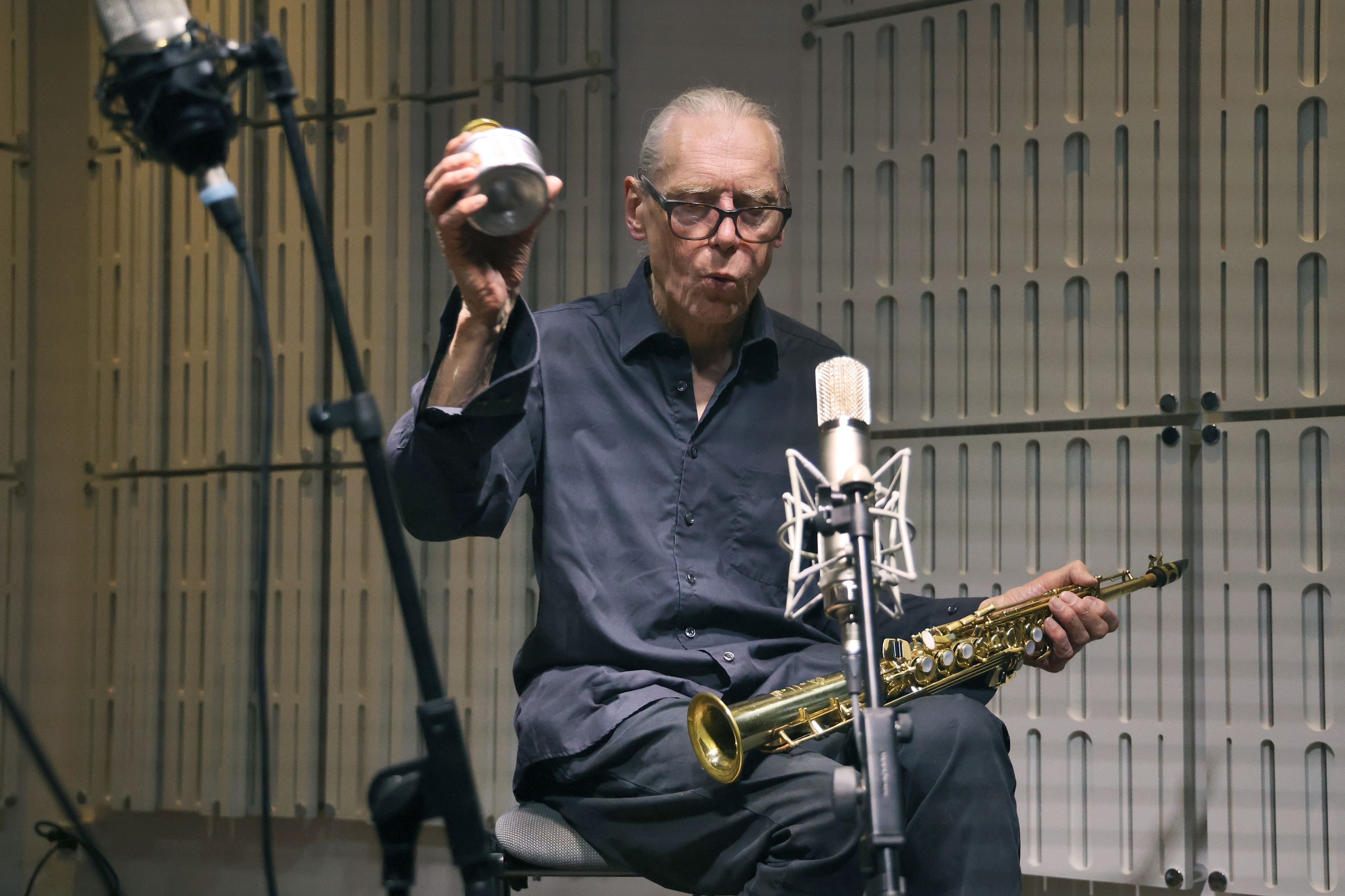 Promobild mit dem Musiker Urs Leimgruber und in der Hand verschiedene Instrumente