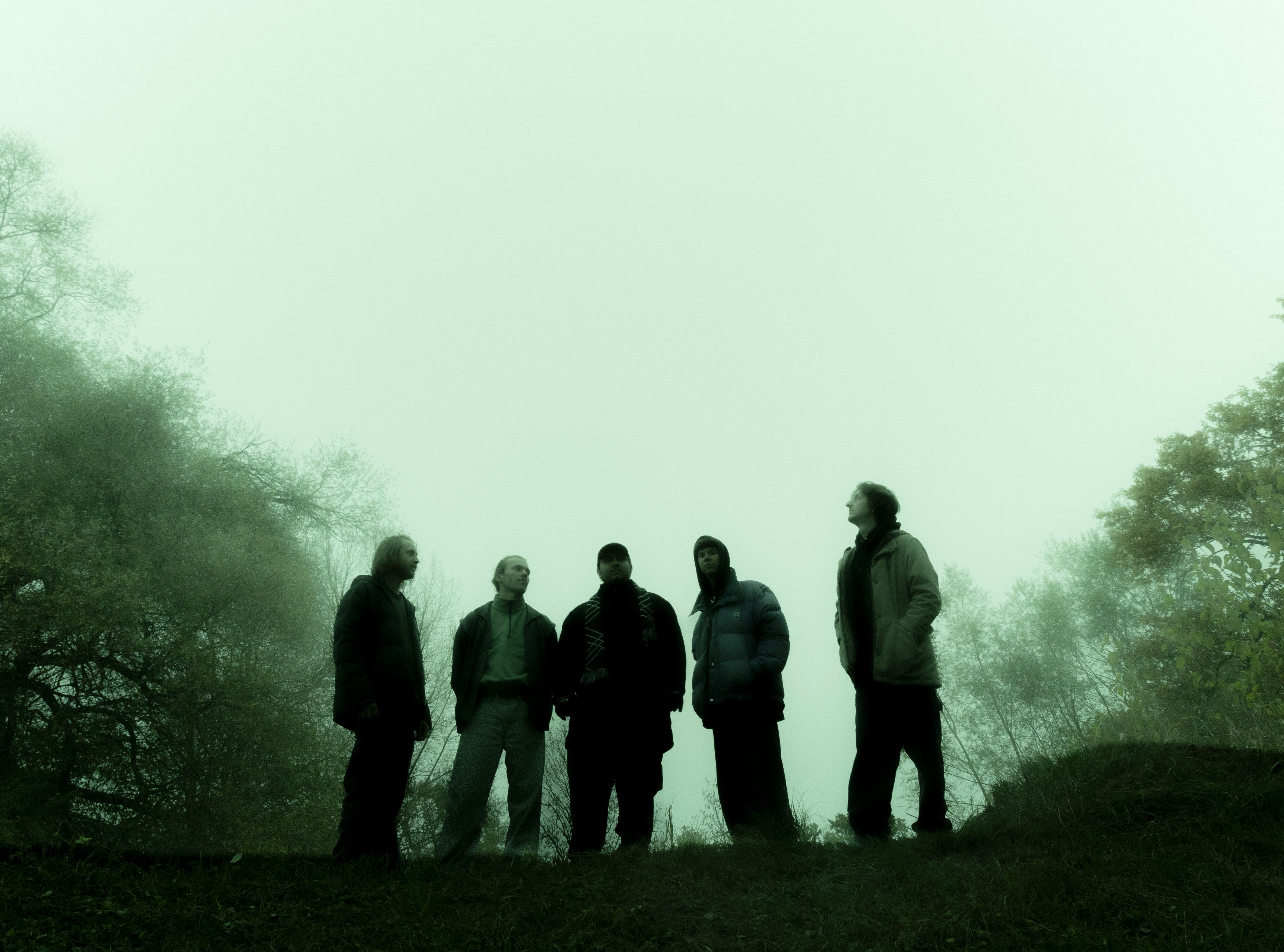 Ein Porträt der Band vor grünem Hintergrund